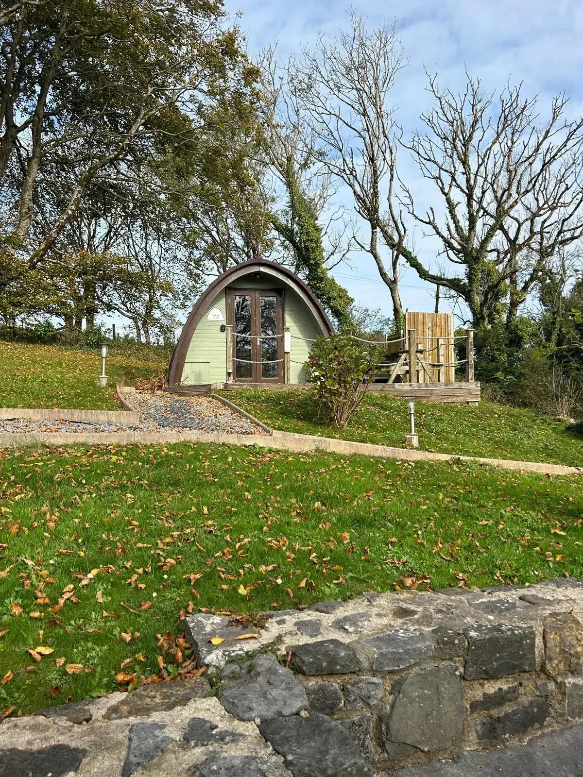 Pods @ Broadway grounds in summer sunshine, with the covered gazebo and gravel paths