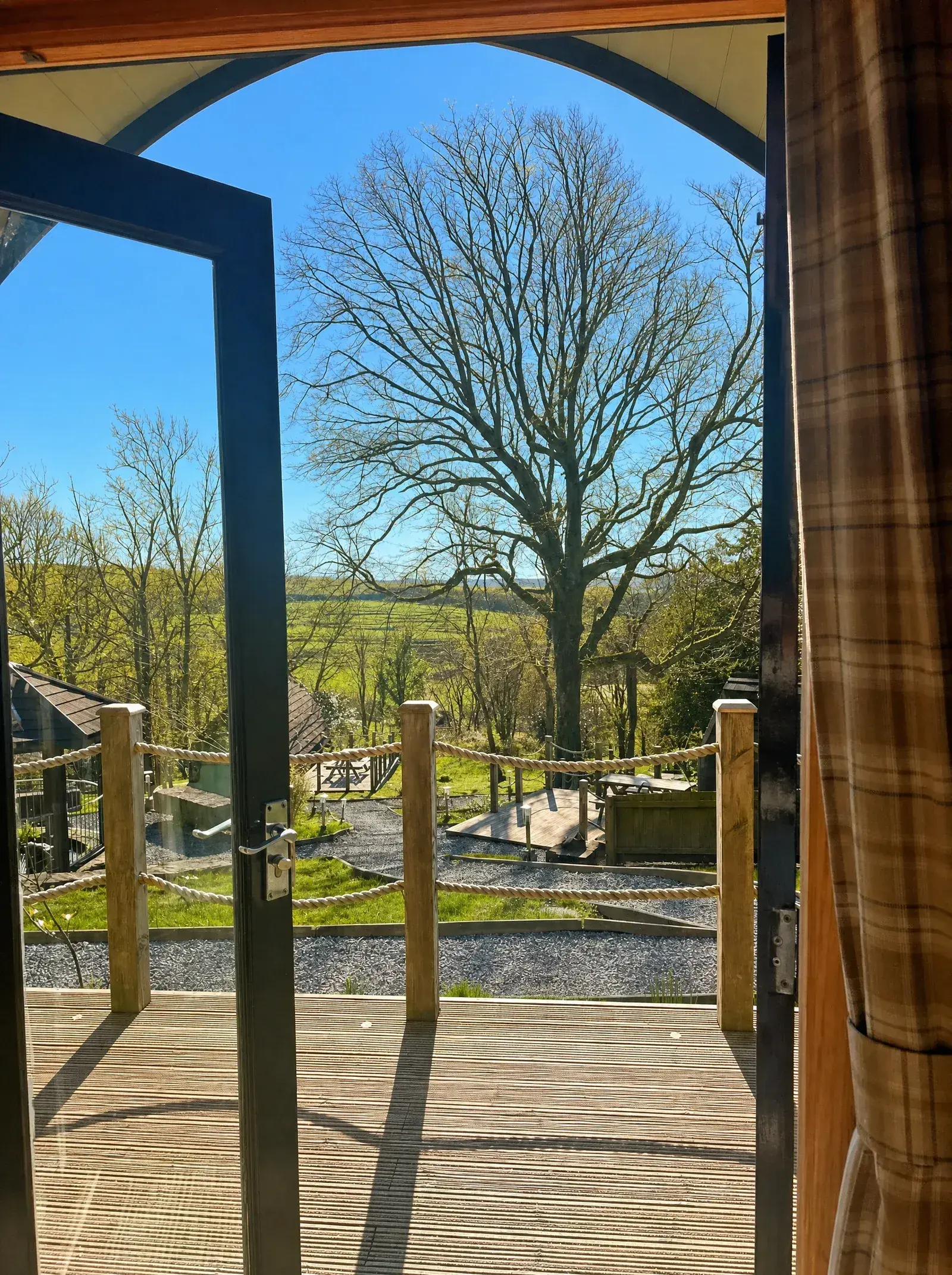 View across the Carmarthenshire countryside from a glamping pod doorway and private decking